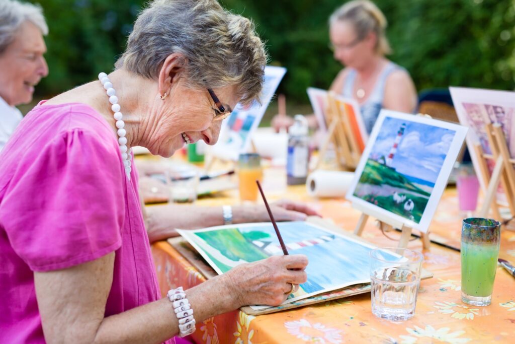 A senior woman in a social activity while painting on a paper