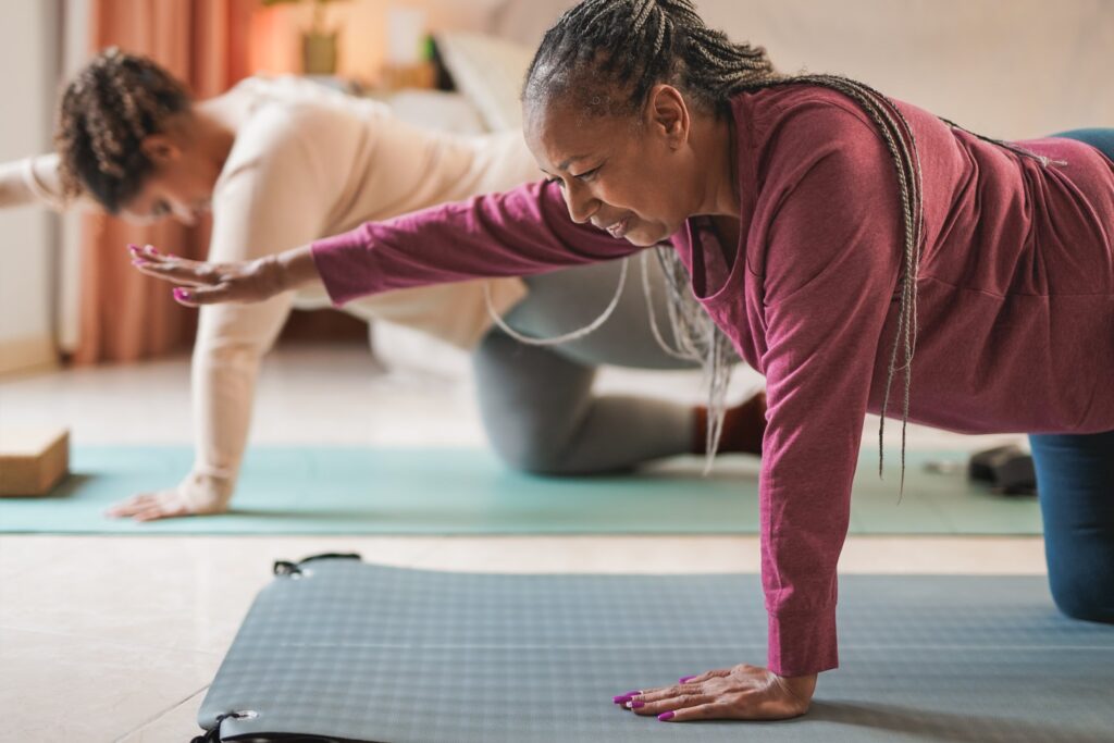 Senior woman practicing yoga, enhancing flexibility in a yoga class, showing the importance of regular physical activity for eye health.