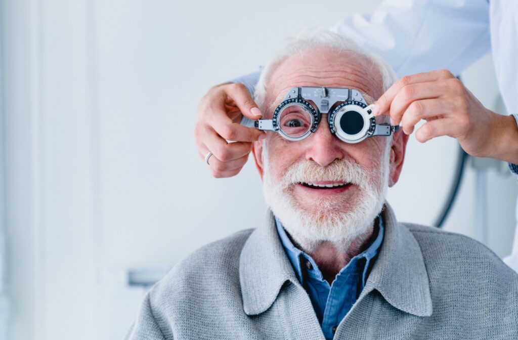 Older adult smiling during an eye exam, having their vision retested after undergoing MacuMira treatment for dry age-related macular degeneration